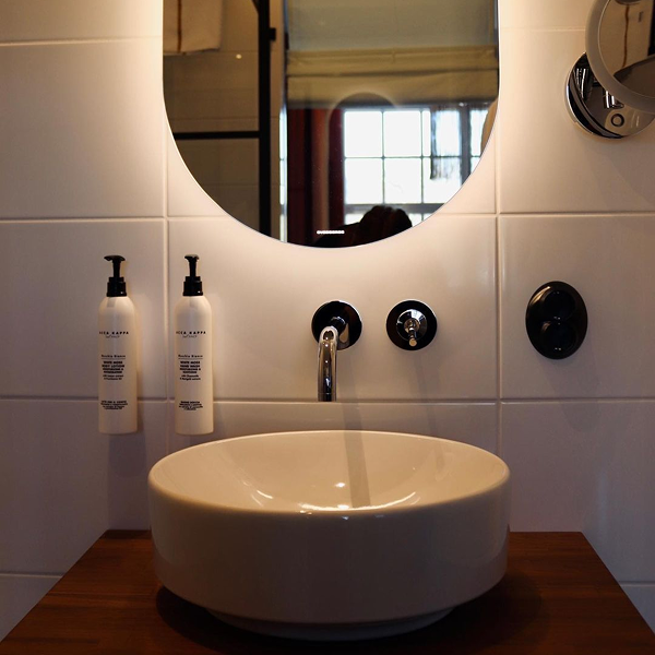 Badrumsrenovering Göteborg – kaklat badrum med kommod och spegelbelysning